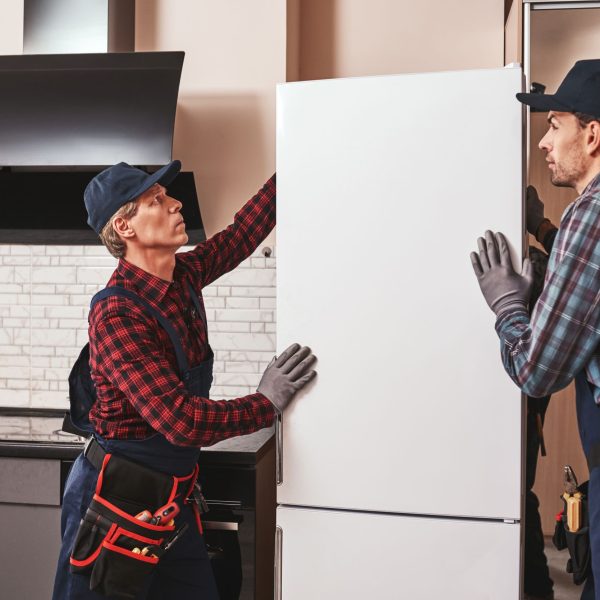 Twee mannen die een koelkast verplaatsen